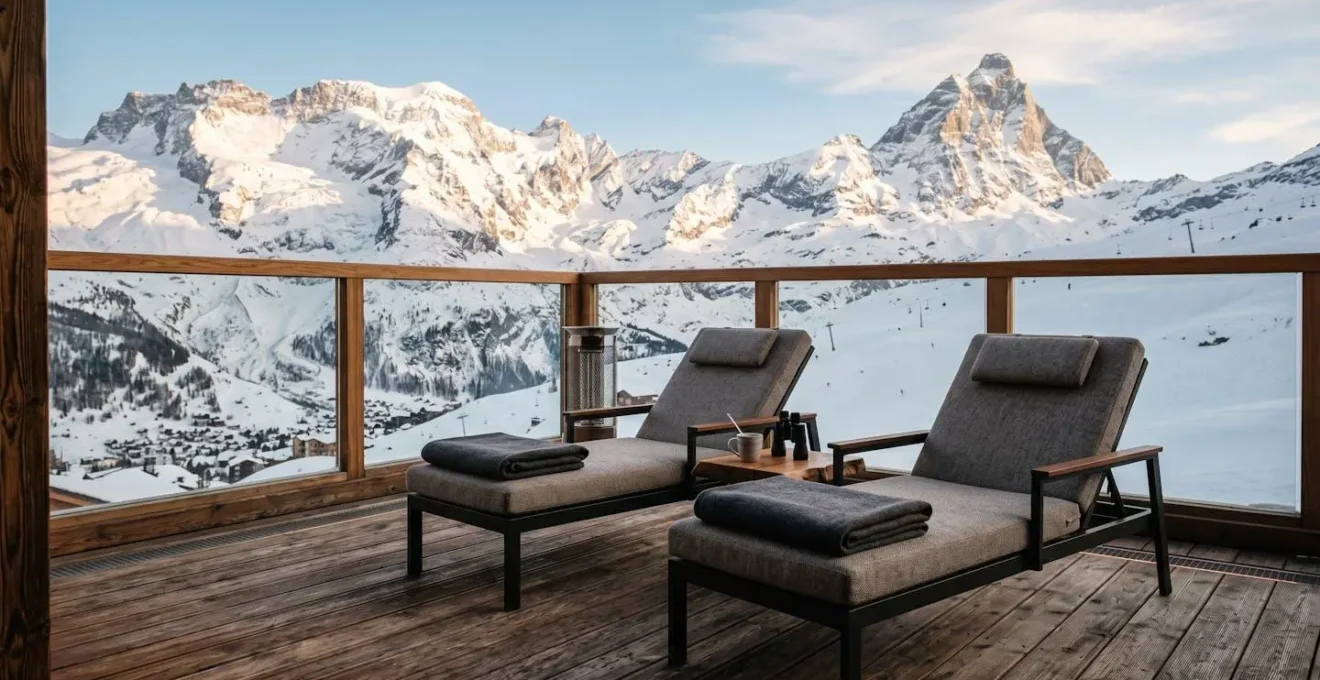 Terrasse en bois chauffée d'un chalet de luxe avec vue dégagée sur les sommets enneigés des Alpes françaises